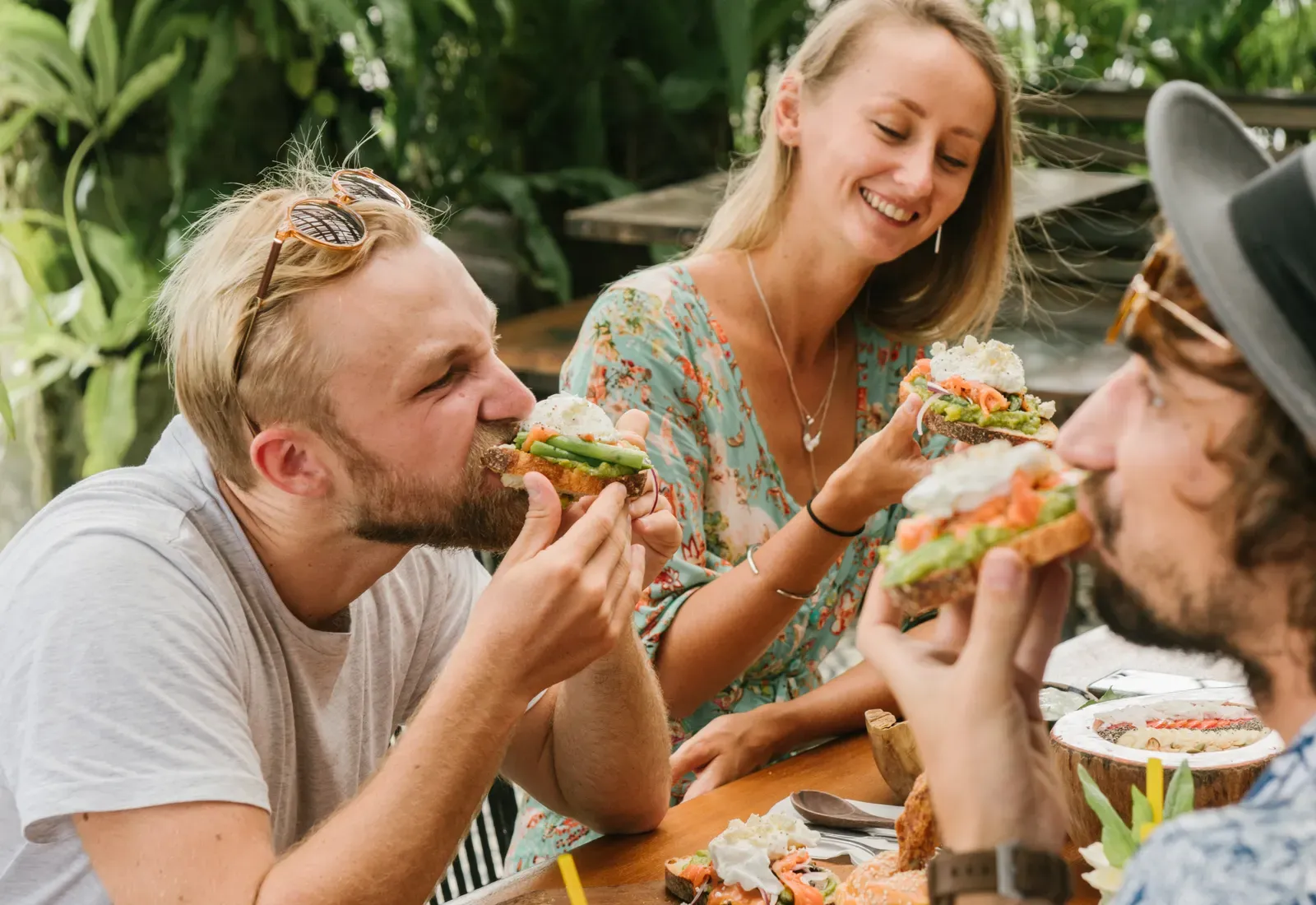 Eine Gruppe Freundinnen und Freunde isst gemeinsam im Freien